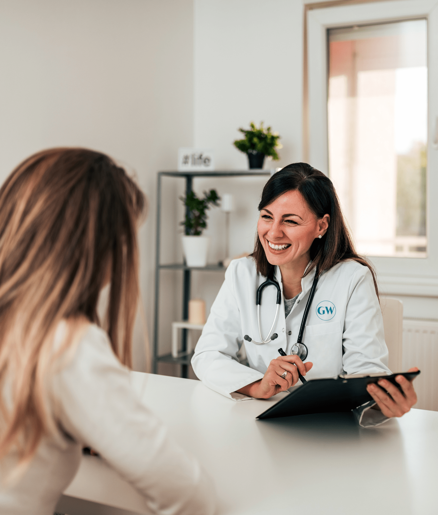 Female primary care doctor speaking with a patient during an in-office visit
